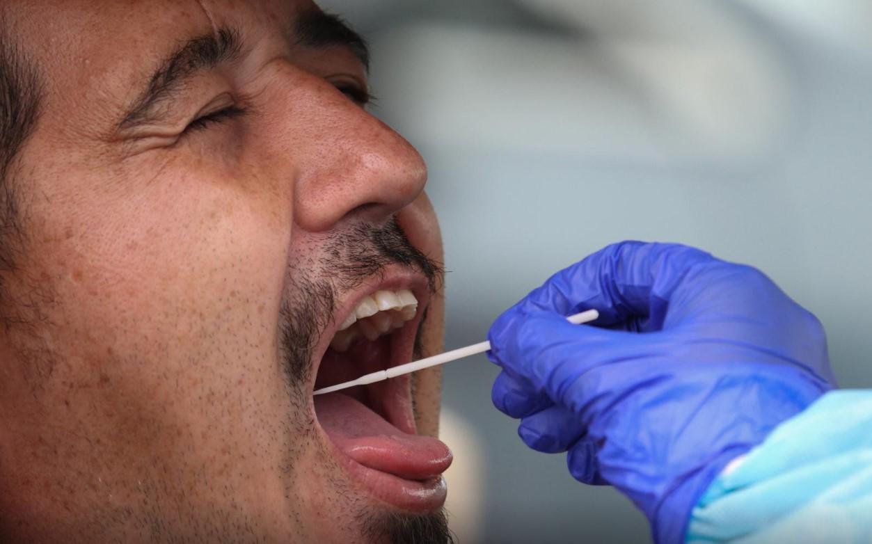 A person is swabbed by a medical professional at a drive-through coronavirus disease (COVID-19) testing clinic in the Warriewood suburb of Sydney, Australia, December 18, 2020. - Avaz